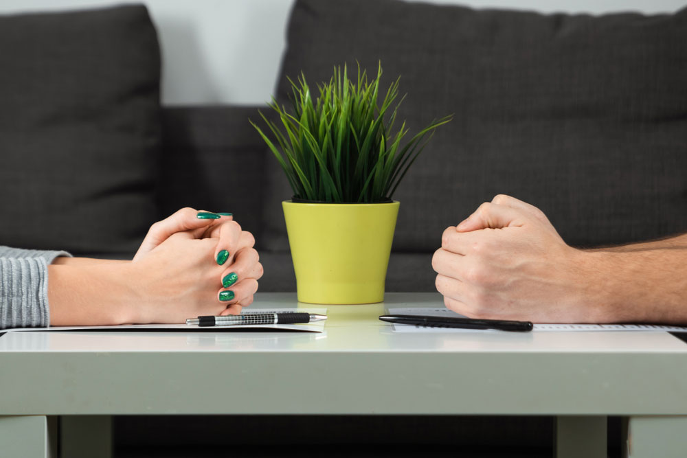 Male and female hands are folded opposite each other